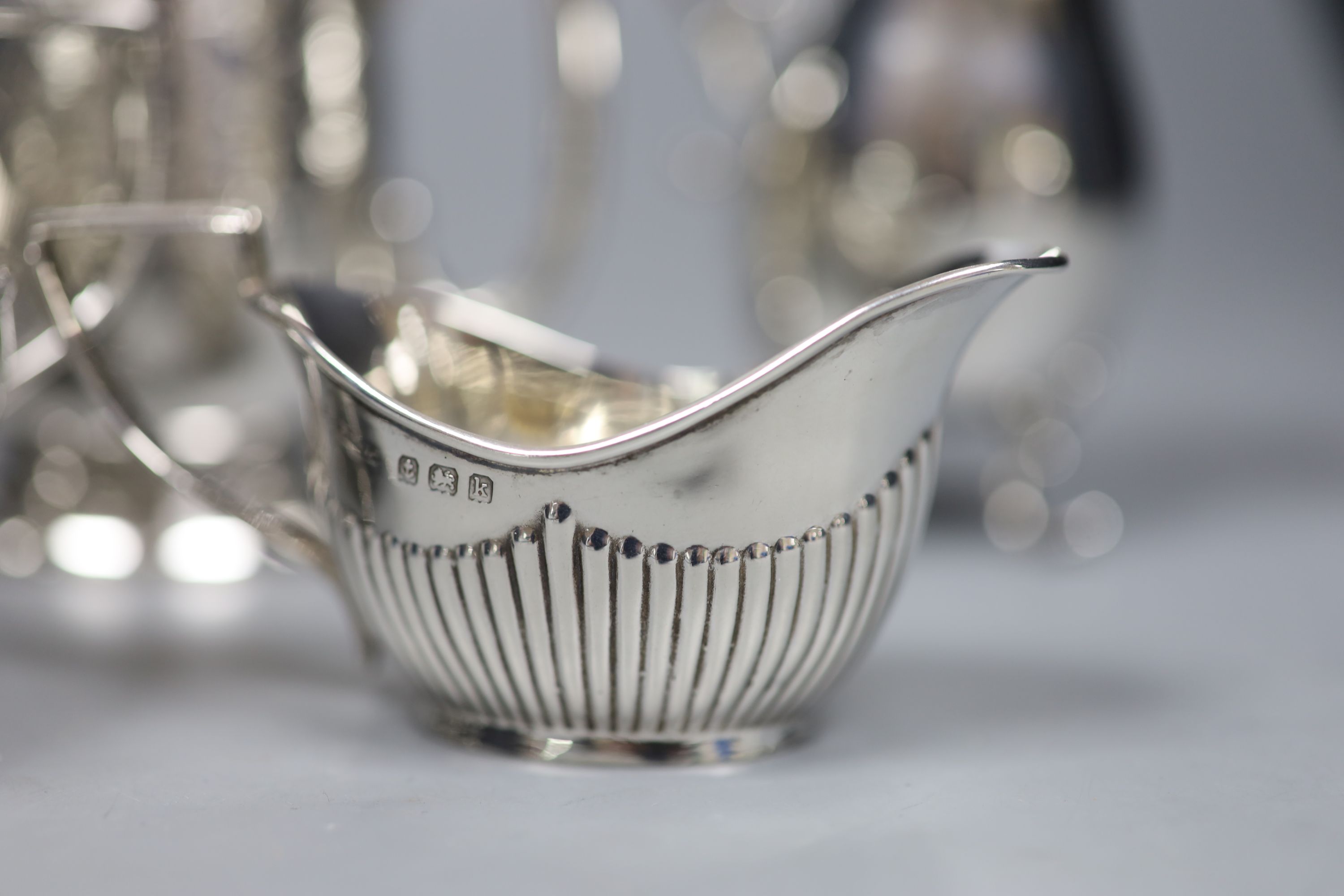 A Victorian engraved silver footed Christening mug and four silver cream jugs, various, 12.3 oz approx